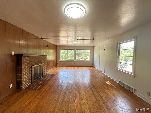 1203 N Main St, Salem, MO 65560 - unfurnished living room featuring wood finished floors, a fireplace, and wooden walls