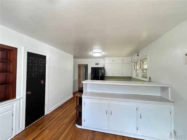 1203 N Main St, Salem, MO 65560 - kitchen with black fridge, light countertops, a peninsula, and white cabinets