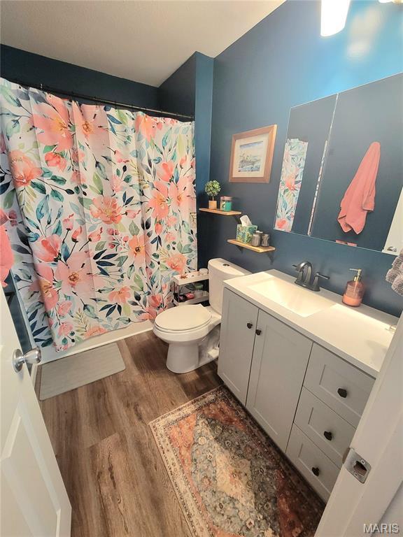 346 Cartpath Ln, Saint Clair, MO 63077 - full bath featuring wood finished floors, vanity, and a shower with shower curtain
