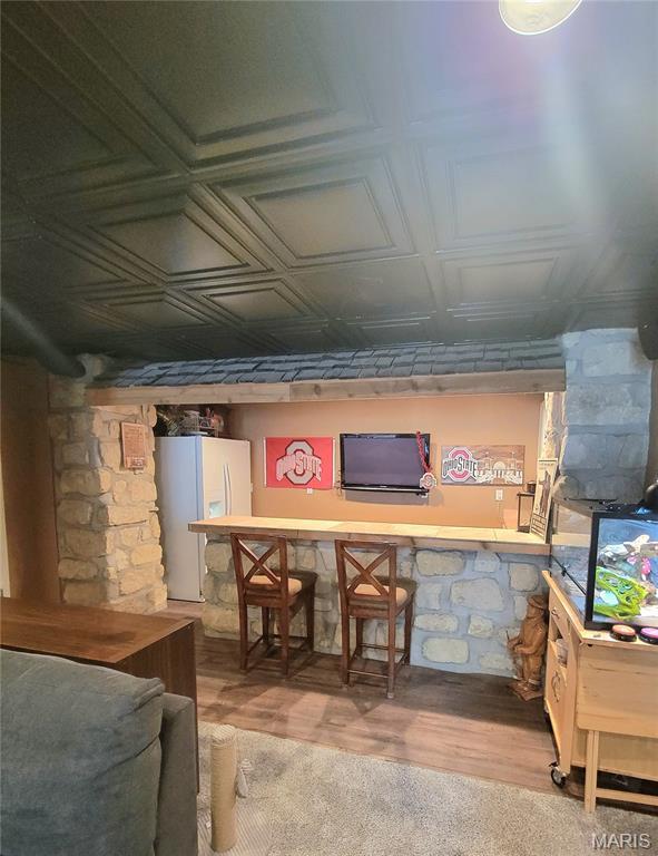 346 Cartpath Ln, Saint Clair, MO 63077 - basement featuring white refrigerator with ice dispenser, an ornate ceiling, and wood finished floors