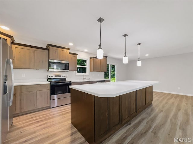 326 State Highway W Rd, Macks Creek, MO 65786 - kitchen with stainless steel appliances, light wood finished floors, a kitchen island, light countertops, and hanging light fixtures
