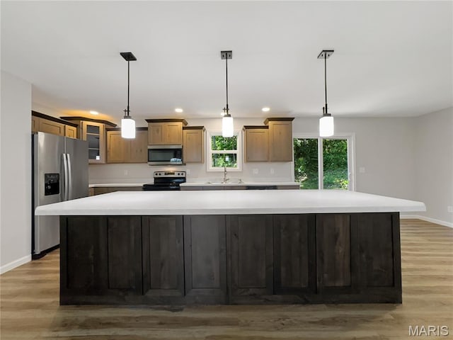 326 State Highway W Rd, Macks Creek, MO 65786 - kitchen with stainless steel appliances, recessed lighting, light countertops, a large island, and light wood-style floors
