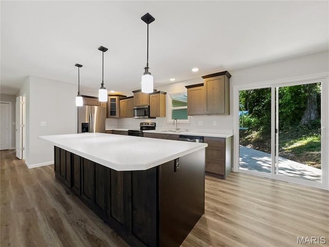 326 State Highway W Rd, Macks Creek, MO 65786 - kitchen featuring appliances with stainless steel finishes, light wood-style floors, light countertops, glass insert cabinets, and a kitchen island