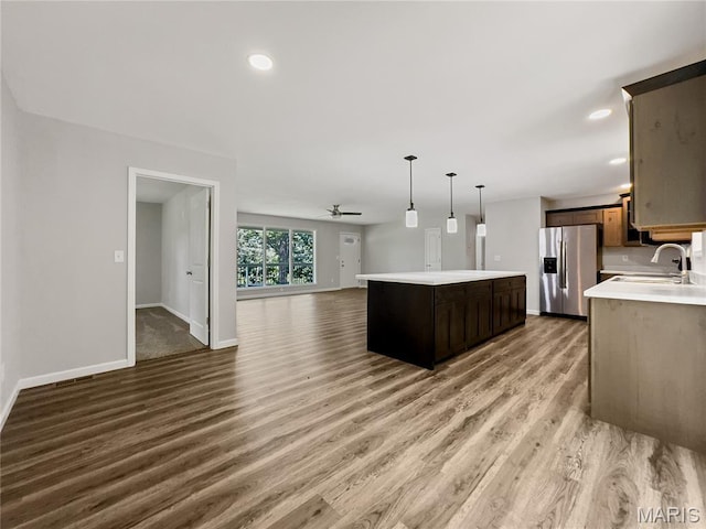 326 State Highway W Rd, Macks Creek, MO 65786 - kitchen with stainless steel refrigerator with ice dispenser, open floor plan, light wood-style flooring, a kitchen island, and light countertops