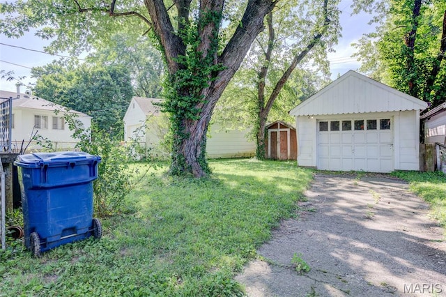 8232 Davenport Dr, Berkeley, MO 63134 - view of grassy yard featuring an outdoor structure, a garage, and driveway