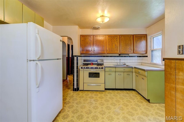 8232 Davenport Dr, Berkeley, MO 63134 - kitchen with white appliances, light countertops, light flooring, arched walkways, and tasteful backsplash