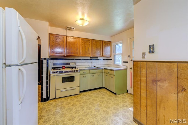 8232 Davenport Dr, Berkeley, MO 63134 - kitchen with white appliances, wainscoting, brown cabinets, light flooring, and light countertops