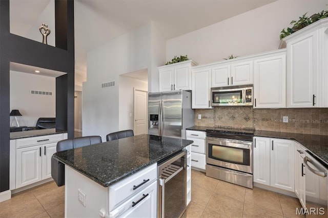 437 Marbleton Cir, Ofallon, IL 62269 - kitchen with appliances with stainless steel finishes, wine cooler, high vaulted ceiling, backsplash, and light tile patterned floors