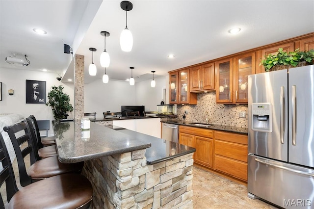 437 Marbleton Cir, Ofallon, IL 62269 - kitchen with appliances with stainless steel finishes, brown cabinets, decorative backsplash, a kitchen breakfast bar, and glass insert cabinets