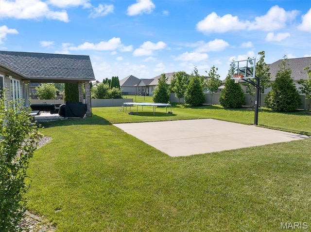 437 Marbleton Cir, Ofallon, IL 62269 - fenced backyard featuring a trampoline, basketball court, and a patio area