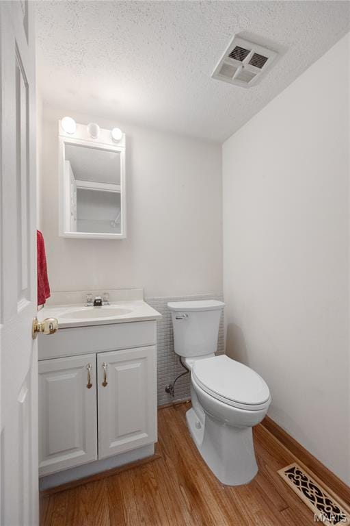 2417 Charente Dr, Maryland Heights, MO 63043 - half bath with a textured ceiling, vanity, and wood finished floors