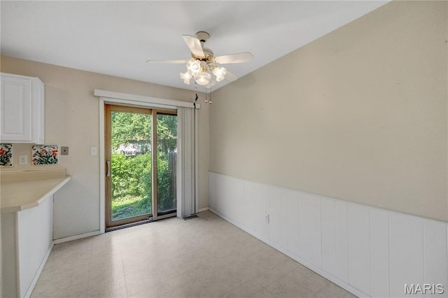 2417 Charente Dr, Maryland Heights, MO 63043 - unfurnished dining area featuring ceiling fan, a wainscoted wall, and light floors