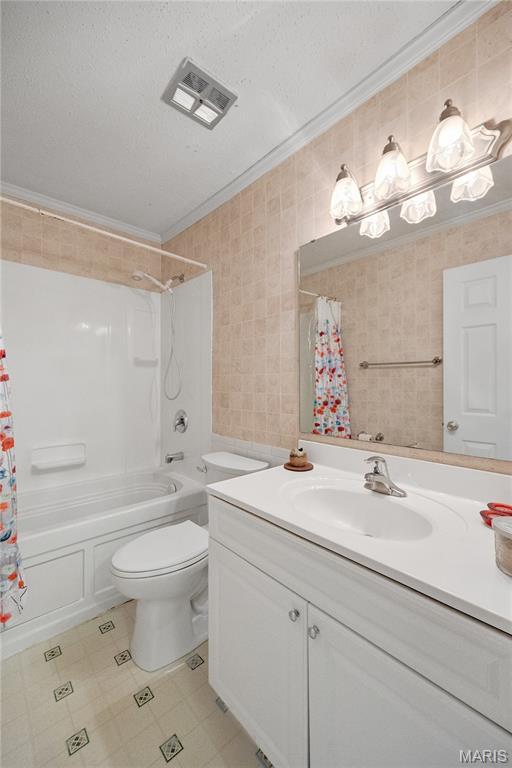 2417 Charente Dr, Maryland Heights, MO 63043 - full bath featuring vanity, shower / bathtub combination with curtain, crown molding, and tile patterned flooring