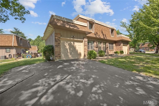 2417 Charente Dr, Maryland Heights, MO 63043 - view of front of home with brick siding, a garage, a front lawn, mansard roof, and asphalt driveway