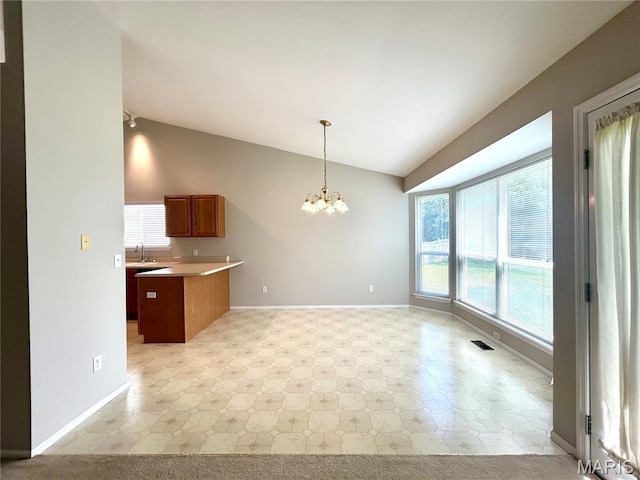 2401 Mountain Range Ct, Pacific, MO 63069 - kitchen with lofted ceiling, a chandelier, a peninsula, open floor plan, and brown cabinetry