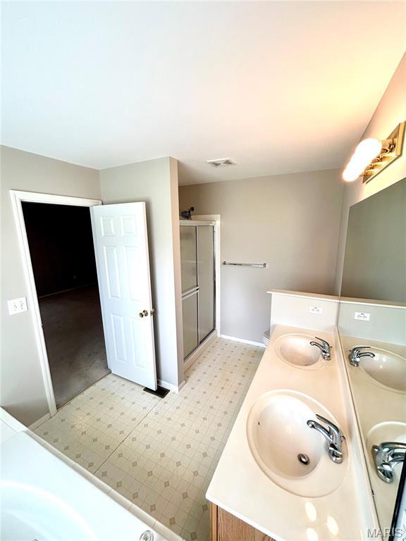 2401 Mountain Range Ct, Pacific, MO 63069 - bathroom featuring a shower stall, double vanity, and a tub to relax in