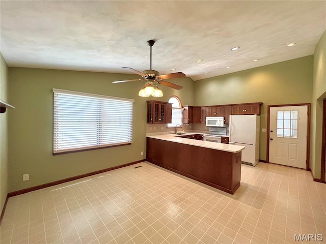 138 S 33rd St, Belleville, IL 62226 - kitchen with white appliances, a peninsula, light countertops, a ceiling fan, and glass insert cabinets
