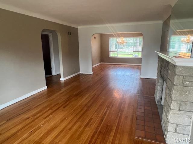 6721 Itaska St, Saint Louis, MO 63109 - unfurnished living room with a chandelier, arched walkways, wood finished floors, and ornamental molding