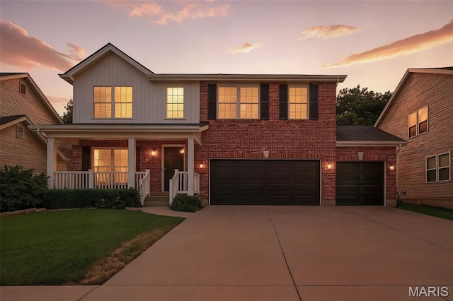 2426 Guardian Ct, Arnold, MO 63010 - view of front of home featuring covered porch, concrete driveway, brick siding, a yard, and board and batten siding