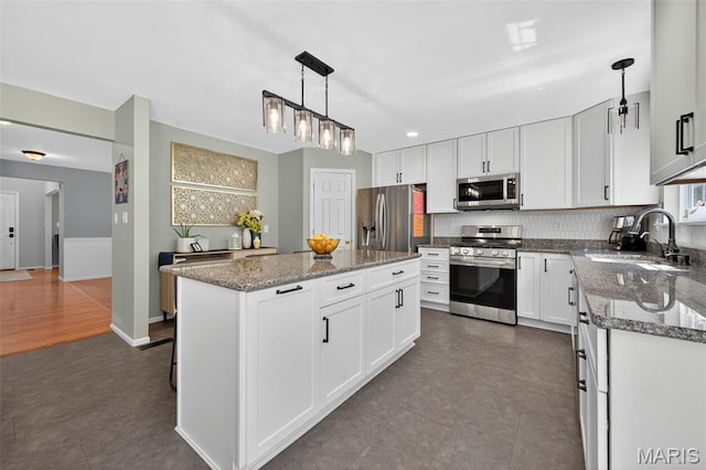 2426 Guardian Ct, Arnold, MO 63010 - kitchen with stainless steel appliances, a kitchen island, white cabinets, dark tile patterned flooring, and recessed lighting