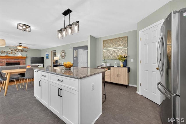 2426 Guardian Ct, Arnold, MO 63010 - kitchen featuring freestanding refrigerator, a kitchen island, a ceiling fan, light stone countertops, and white cabinetry