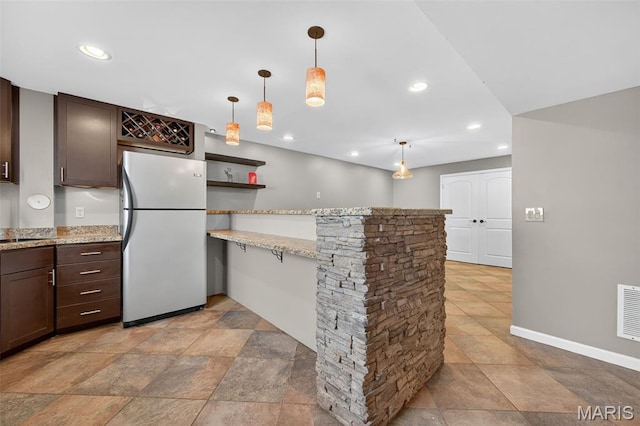 2426 Guardian Ct, Arnold, MO 63010 - kitchen with freestanding refrigerator, dark brown cabinetry, a peninsula, recessed lighting, and pendant lighting