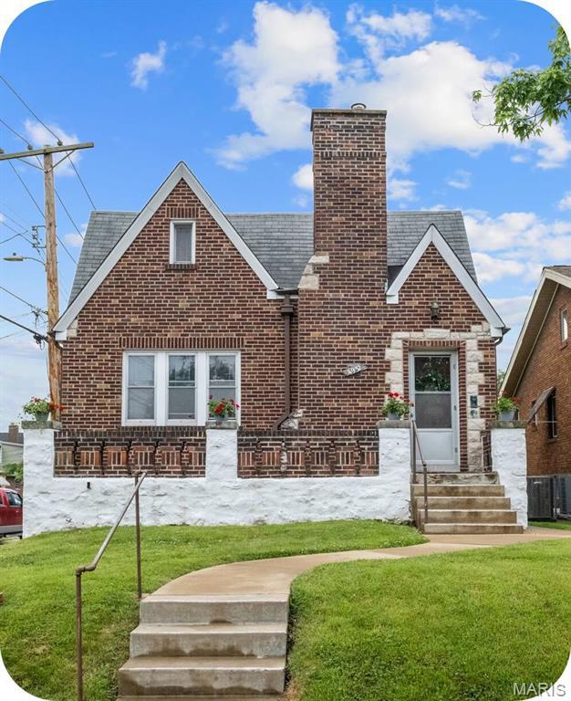 4932 Fairview Ave, Saint Louis, MO 63139 - tudor home with brick siding, a chimney, and a front yard
