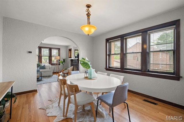 4932 Fairview Ave, Saint Louis, MO 63139 - dining room with arched walkways, a textured wall, and wood finished floors