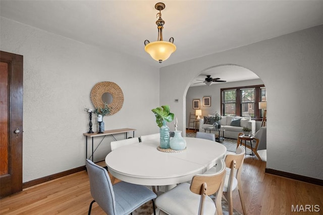 4932 Fairview Ave, Saint Louis, MO 63139 - dining room with arched walkways, light wood-style flooring, ceiling fan, and a textured wall