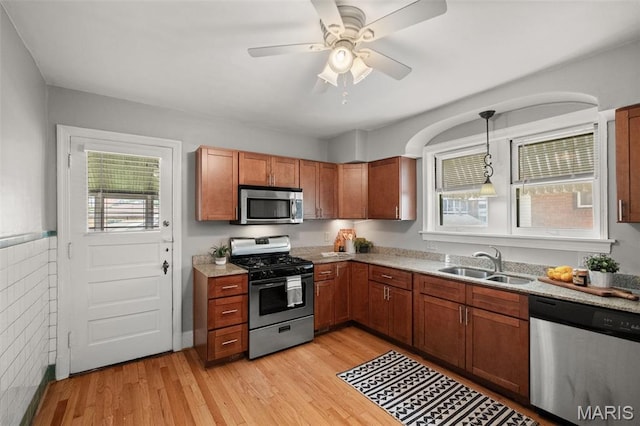 4932 Fairview Ave, Saint Louis, MO 63139 - kitchen featuring appliances with stainless steel finishes, light wood-type flooring, brown cabinets, and ceiling fan