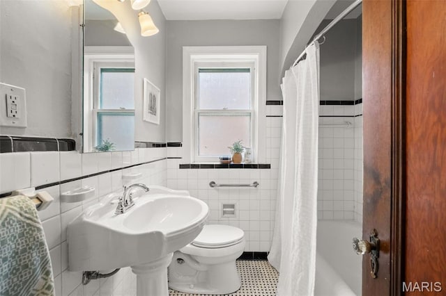 4932 Fairview Ave, Saint Louis, MO 63139 - full bathroom with tile walls, a wainscoted wall, and shower / tub combo