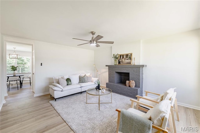 7315 Cheshire Ln, Affton, MO 63123 - living area with light wood finished floors, a ceiling fan, and a fireplace
