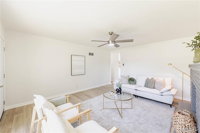 7315 Cheshire Ln, Affton, MO 63123 - living area featuring a ceiling fan, light wood-style floors, and a brick fireplace