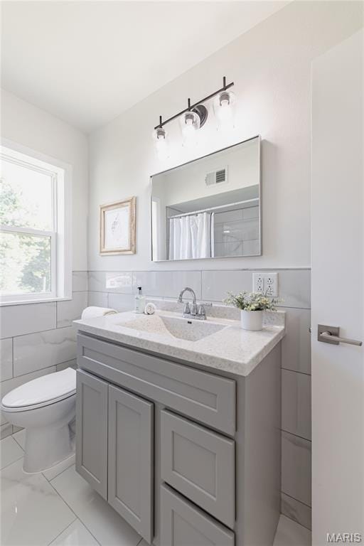 7315 Cheshire Ln, Affton, MO 63123 - full bathroom featuring vanity, tile walls, marble finish floors, curtained shower, and a wainscoted wall
