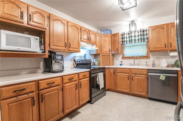 921 Mallard Sq, Rolla, MO 65401 - kitchen with black range with electric stovetop, stainless steel dishwasher, white microwave, under cabinet range hood, and light countertops