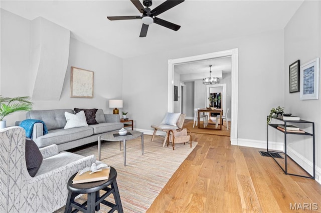 2725 Macklind Ave, Saint Louis, MO 63139 - living room with light wood-type flooring, ceiling fan, and a chandelier