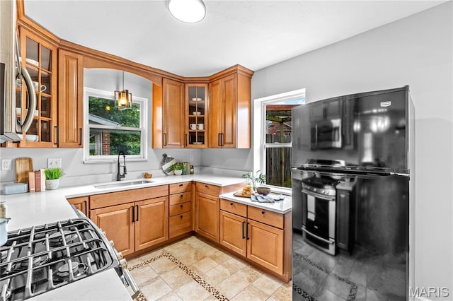 2725 Macklind Ave, Saint Louis, MO 63139 - kitchen with freestanding refrigerator, brown cabinetry, light countertops, and gas stove