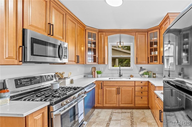 2725 Macklind Ave, Saint Louis, MO 63139 - kitchen featuring stainless steel appliances, brown cabinets, glass insert cabinets, and light countertops