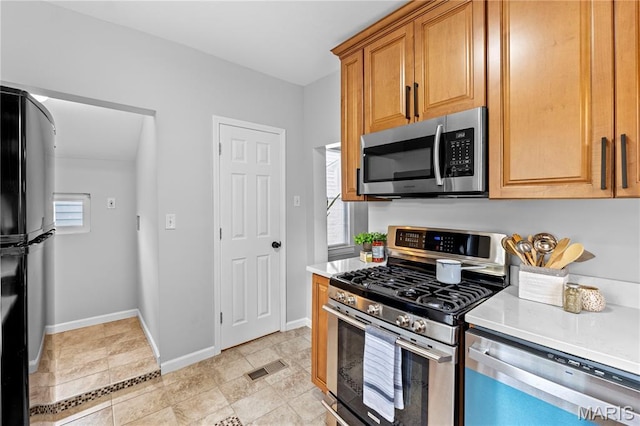 2725 Macklind Ave, Saint Louis, MO 63139 - kitchen featuring stainless steel appliances, light countertops, and light tile patterned floors