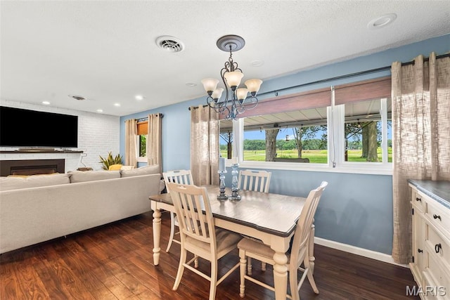8114 Montclaire Ave, Brighton, IL 62012 - dining room featuring dark wood-type flooring, a chandelier, recessed lighting, and a fireplace