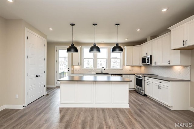 1347 W Gateway Hts W Unit 53-603, Richmond Heights, MO 63144 - kitchen with stainless steel appliances, a center island, light wood-style floors, backsplash, and recessed lighting