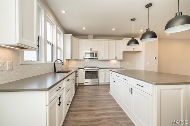 1347 W Gateway Hts W Unit 53-603, Richmond Heights, MO 63144 - kitchen with appliances with stainless steel finishes, tasteful backsplash, white cabinetry, dark countertops, and recessed lighting