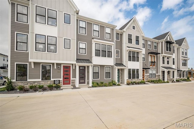 1347 W Gateway Hts W Unit 53-603, Richmond Heights, MO 63144 - townhome / multi-family property with board and batten siding, stone siding, a residential view, and a standing seam roof