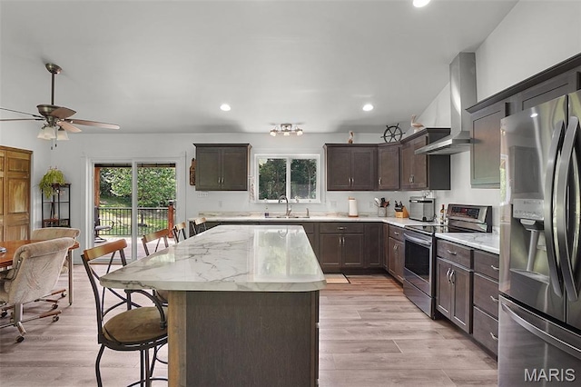 8224 Wild Acre Meadows Dr, Hillsboro, MO 63050 - kitchen featuring stainless steel appliances, wall chimney range hood, a kitchen breakfast bar, dark brown cabinetry, and a kitchen island