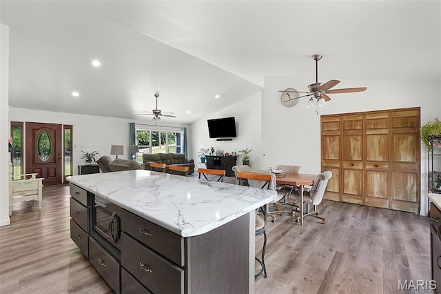 8224 Wild Acre Meadows Dr, Hillsboro, MO 63050 - kitchen featuring a ceiling fan, vaulted ceiling, stainless steel microwave, light wood-type flooring, and a kitchen island