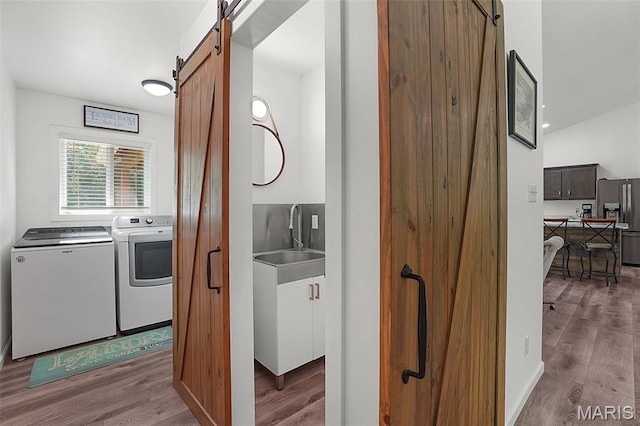 8224 Wild Acre Meadows Dr, Hillsboro, MO 63050 - laundry area featuring a barn door, washing machine and dryer, and wood finished floors