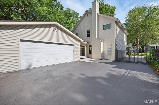 432 Clark Ave, Webster Groves, MO 63119 - view of front of property featuring a chimney, asphalt driveway, and an outbuilding