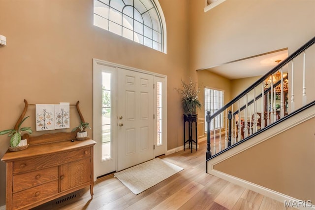 3026 Windsor Point Dr, Saint Louis, MO 63129 - entryway with stairway, a high ceiling, healthy amount of natural light, and light wood-style floors