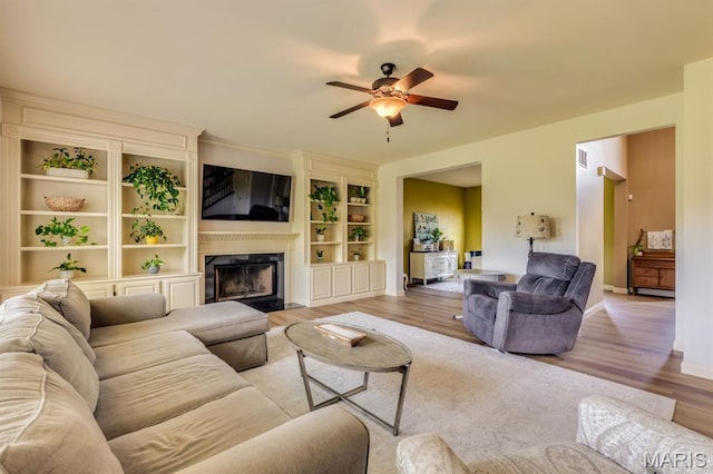 3026 Windsor Point Dr, Saint Louis, MO 63129 - living area featuring ceiling fan, wood finished floors, a premium fireplace, and built in shelves