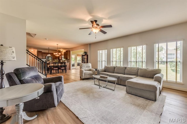 3026 Windsor Point Dr, Saint Louis, MO 63129 - living area with a chandelier, light wood-type flooring, ceiling fan, and stairway